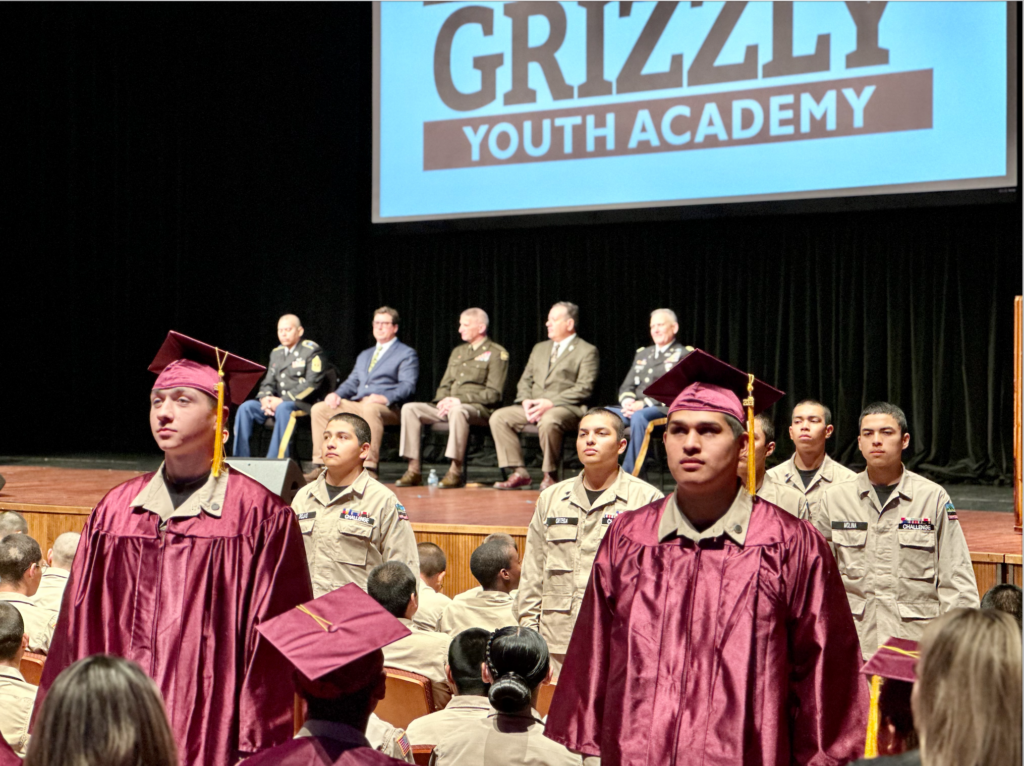 A group of Grizzly Academy students at graduation, some in uniforms.