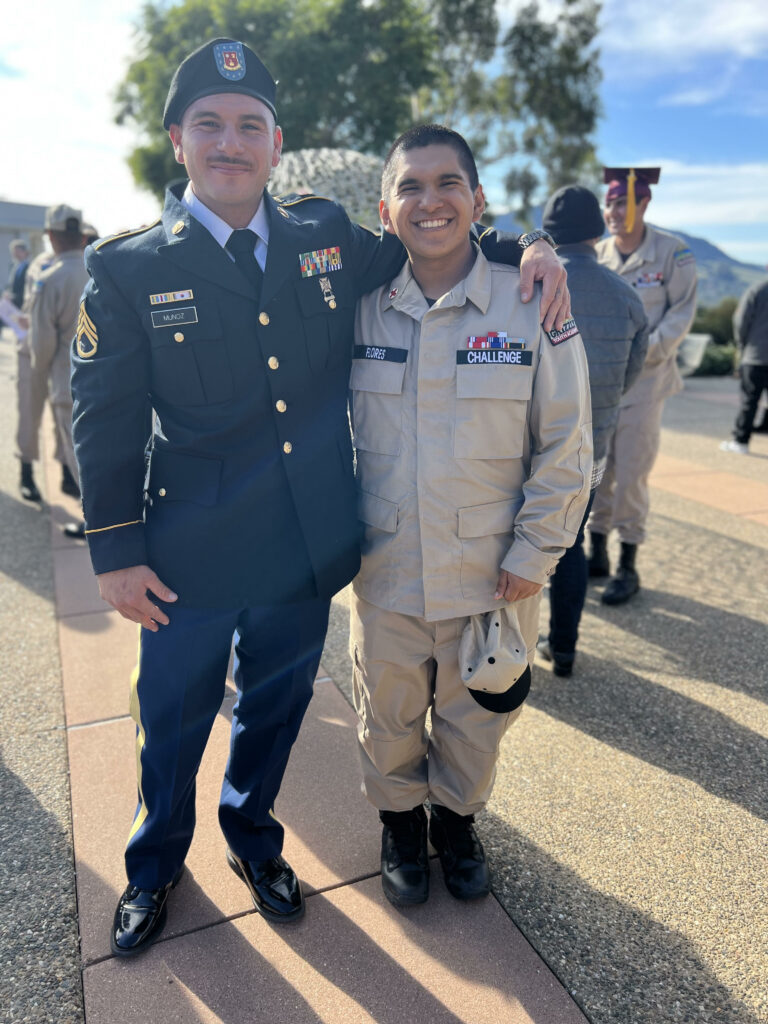 A student with a staff member, both in uniform